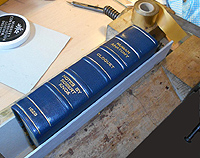 Gold being applied to the spine of a book